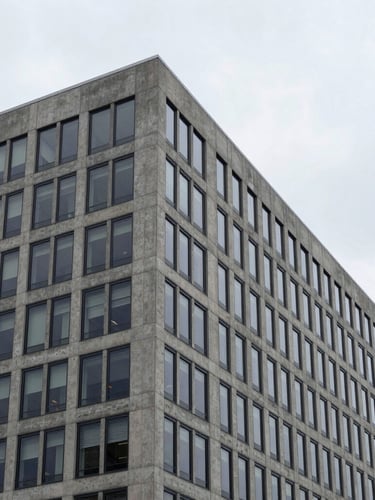 Crisp corporate photography of a modern concrete and glass office building in Ontario, cool overcast daylight, sharp architectural angles, 35mm lens.