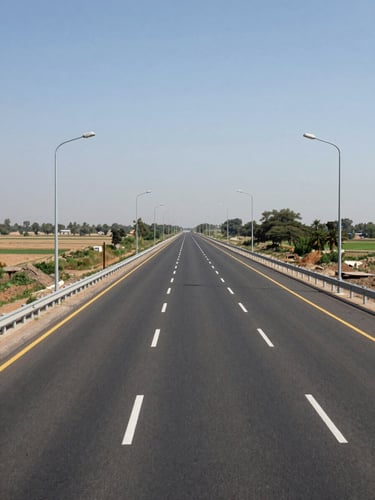 Wide ground-level shot along a newly constructed four-lane highway in Haryana, road markings sharp and clear, streetlights installed on both sides, flat agricultural land receding to the horizon on the left, natural midday daylight, no vehicles, no people — infrastructure readiness evident in the empty road