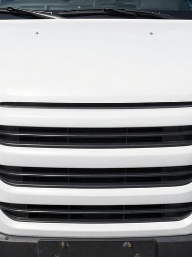 Close-up detail shot of a clean white commercial van grille and hardware, bright natural daylight, high contrast, industrial setting.