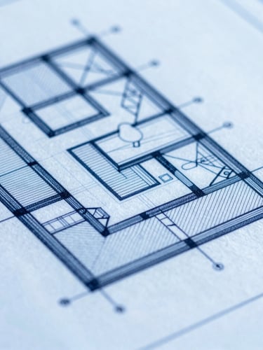 Macro close-up of a highly detailed architectural blueprint, crisp blue lines on clean white drafting paper, sharp shadows under cool-toned daylight, 35mm photography