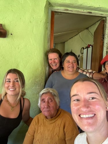 A group of four people posing for a selfie inside a rustic home.