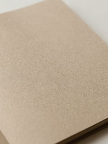 Close-up of a tactile embossed paper brand book, warm sand and taupe tones, soft natural daylight, minimalist composition, 35mm