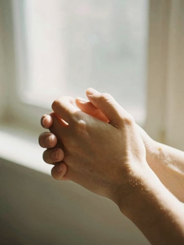 A close-up of hands gently holding hands in warm, natural window light, soft golden tones, authentic and compassionate, 35mm