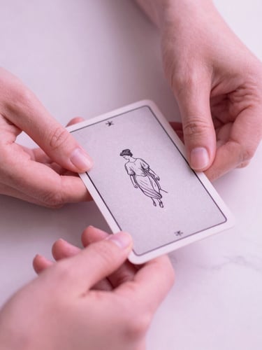Close-up macro shot of elegant hands holding a beautifully illustrated minimalist tarot card over a clean white marble desk, soft diffused pink light, 35mm