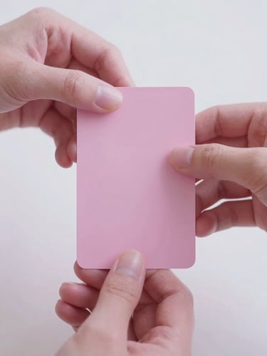 Close-up macro shot of elegant hands gently holding a minimalist pink tarot card, soft ethereal white and pink light, shallow depth of field, 35mm