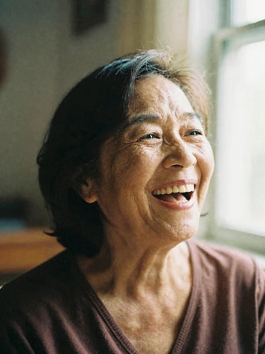 A warm close-up portrait of an active senior woman laughing in a sunlit room, soft natural window light, rich organic tones, shallow depth of field, 35mm film
