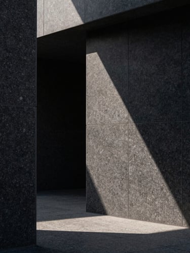 Abstract crop of monolithic dark granite architecture, sharp sunlight casting deep geometric shadows, ultra-clean and quiet luxury