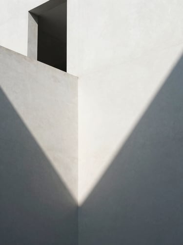 Minimalist modern Hong Kong architecture, sharp directional light casting long geometric shadows on clean white concrete walls, high contrast, editorial look