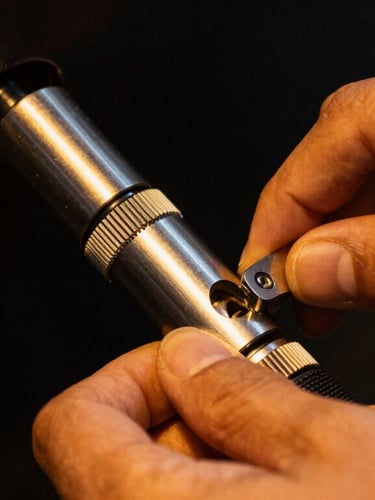 Close-up of hands installing a high-security lock cylinder, dramatic low-light night-time street lighting with warm orange highlights, sharp macro focus