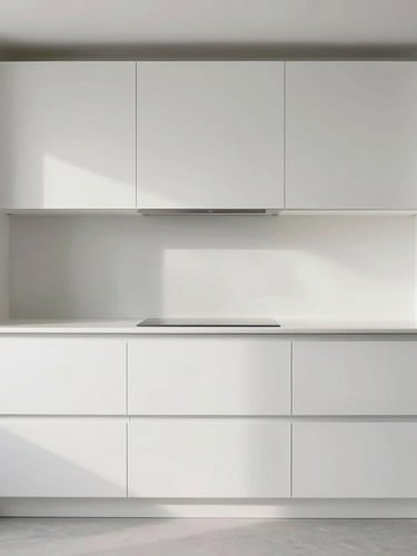 Straight-on architectural elevation of a minimalist white kitchen, diffused natural side-lighting highlighting the flawless lacquered finish and integrated handles, expansive room view.