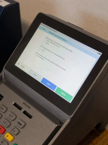 Close-up overhead of a payment terminal screen displaying a completed transaction confirmation in daylight, no people, clean studio light on the interface