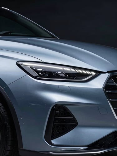 High-contrast studio shot of a pristine premium vehicle with sharp metallic reflections, cool blue and silver tones, professional automotive photography