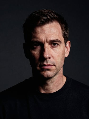 Moody editorial portrait of artist Marek Vance in a sterile studio, sharp focus, high-contrast directional studio lighting, 35mm film