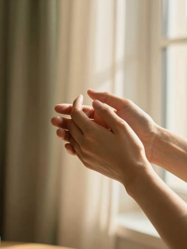 Close-up of two hands gently holding each other, warm golden-hour light filtering through a window, soft-focus residential interior background, rich cream tones