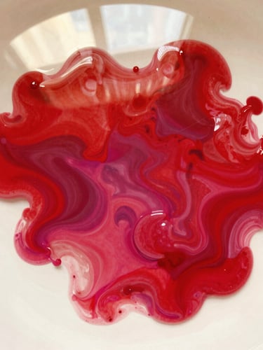 Abstract macro shot of vibrant red and magenta paint blending in water, high contrast, warm editorial photography, 35mm