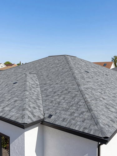 Bright architectural photo of a modern home exterior with clean, newly installed charcoal grey roofing shingles, sunny day, residential neighborhood
