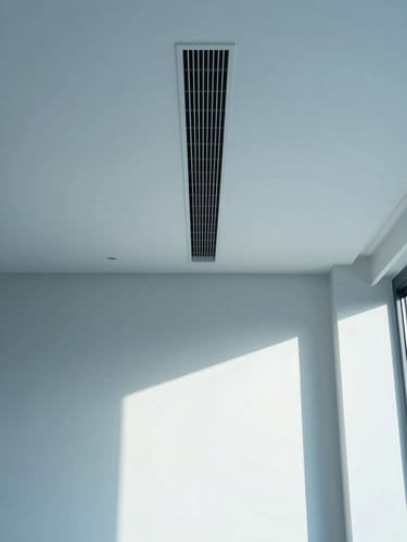 Symmetrical architectural shot of a minimalist luxury living room with an integrated, invisible climate control slot in the ceiling, soft natural side light, cool blue tones, 35mm lens