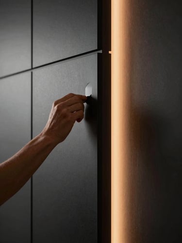 A close-up of a craftsman applying a flawless finish to a modern wall panel, precise lines, beautiful side lighting, high-contrast, premium architectural photography