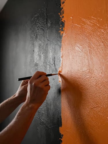 Close-up of a craftsman's hands applying a flawless final coat of textured paint to a modern wall, dramatic side-lighting highlighting the perfect texture, luxury interior