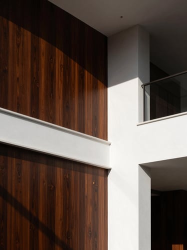 Low-angle architectural shot of a luxury Riyadh villa interior, dramatic side-lighting highlighting a perfectly executed wall transition between dark wood paneling and pristine white plaster, premium architectural photography style