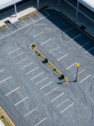 Overhead aerial view of an organized event parking lot at a modern stadium, crisp daylight, high contrast, clean geometric lines, cool blue tones, 35mm
