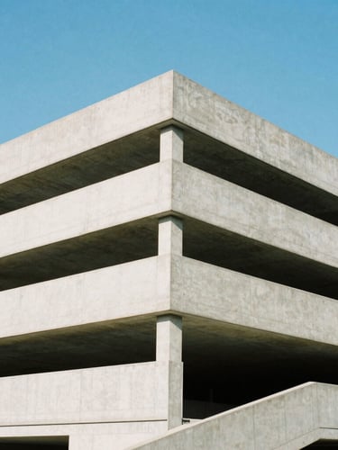 Wide architectural angle of a modern concrete parking structure under bright daylight, clean geometric lines, sharp focus, cool blue sky, 35mm.