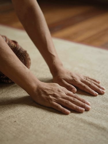 Close-up of skilled hands performing traditional Thai stretching on a clean linen mat, warm low-key teakwood lighting, shallow depth of field, 35mm photography.