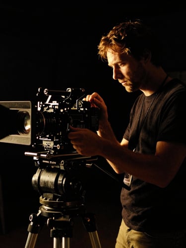 High-contrast cinematic still of a director adjusting a camera rig on a dark set, dramatic golden rim light, deep shadows, 35mm film grain.