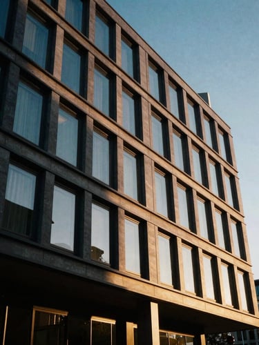Low-angle architectural shot of modern European Union office building in Brussels, golden-hour sunlight casting long shadows, warm editorial style, 35mm