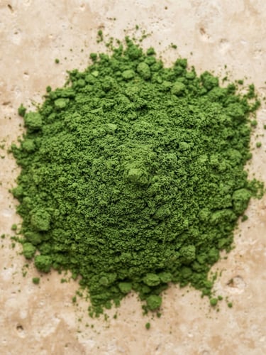 Overhead macro shot of vibrant green moringa powder on a minimalist warm beige stone surface, clean clinical lighting, 50mm lens