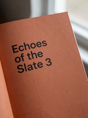 A portrait book mockup of 'Echoes of the Slate' featuring a minimalist terracotta cover with geometric patterns, shot under soft natural light.