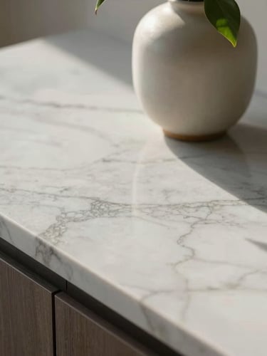 Close-up of a perfectly styled marble countertop catching soft morning light, a single ceramic vase with a delicate green leaf, architectural framing