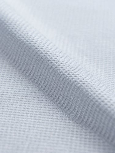 Crisp macro photograph of technical sports fabric texture, showing moisture-wicking capillary weave, bright cool-toned studio lighting, sharp focus, 50mm lens.