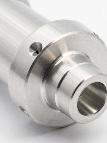 Close-up macro shot of a gleaming CNC-milled billet aluminum aerospace component, bright high-key studio lighting, crisp metallic reflections, clean white background, sharp focus