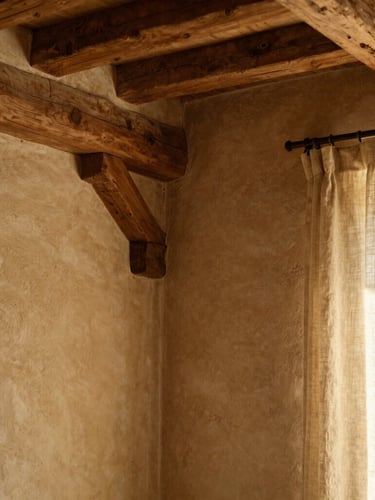 Portrait orientation of a beautifully restored interior corner of the farmhouse, showing exposed oak beams, textured clay walls, and a soft linen curtain catching warm daylight, shallow depth of field.