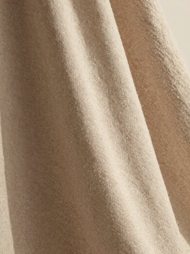 Close-up of premium linen fabric drape, warm natural afternoon light, subtle grain, 35mm lens