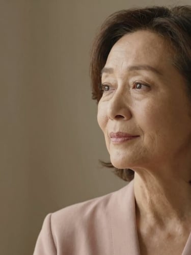 Thoughtful portrait of a mature woman looking away in quiet contemplation, soft window light, warm neutral background, elegant, 35mm