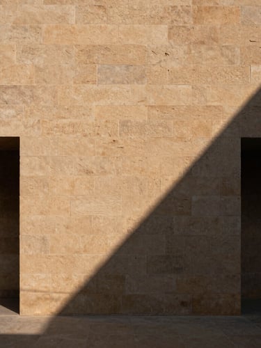 Minimalist architectural crop of a sandstone structural wall in Bhubaneswar, sharp directional sunlight, deep geometric shadows, 35mm lens