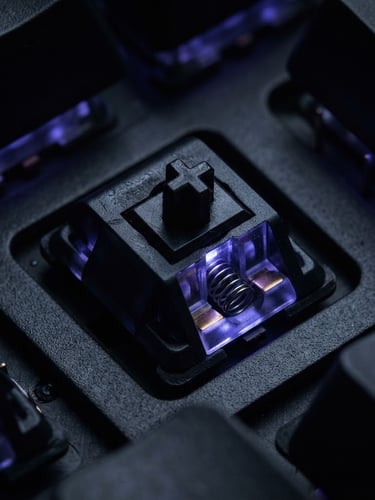 Extreme macro close-up of a sleek black mechanical keyboard switches with deep indigo backlighting, dark moody product photography, studio lighting, obsidian tones