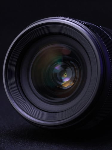 Sleek hardware detail with sharp metallic edges, dark glass reflection, dramatic low-key side-lighting with deep indigo rim light, macro studio photography.