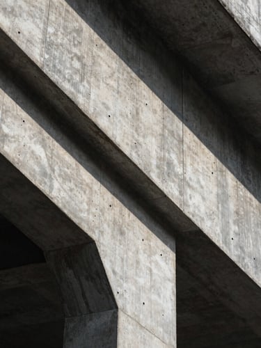 Extreme close-up of brutalist concrete structure, sharp geometric shadows, cool natural light, architectural detail.