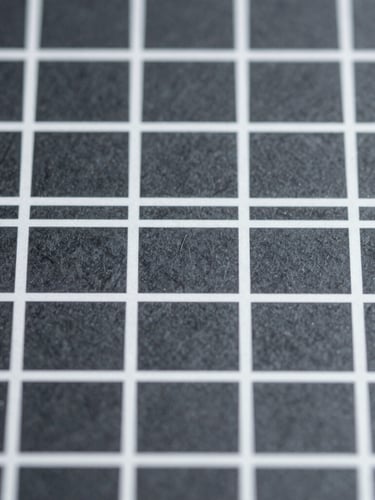 Macro photograph of a structured grid layout on a screen, cool slate tones, sharp typography lines, minimal daylight, 50mm
