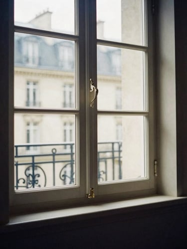 Soft natural daylight reflecting off an elegant architectural window frame in a quiet Parisian office, deep navy shadows, high contrast, warm editorial style, 35mm lens.