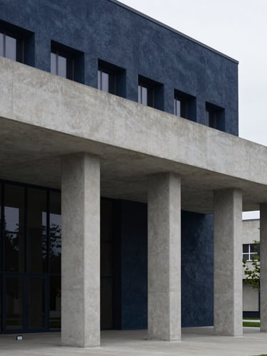 Sober architectural photography of a modern courthouse facade, clean concrete lines, soft diffused daylight, deep navy tones, sharp focus.
