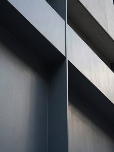 Macro close-up of modern architectural steel lines and concrete, sharp focus, geometric shadows, soft daylight, sober corporate tone