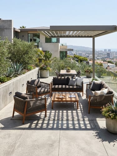 Wide environmental shot of curated high-end outdoor furniture on a concrete architectural terrace, bright natural midday sun with sharp shadows, 35mm lens