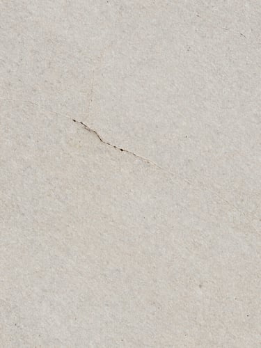 Macro texture shot of a light grey Yorkstone slab showing natural clefts and fine grain, soft overcast daylight, architectural framing, 35mm