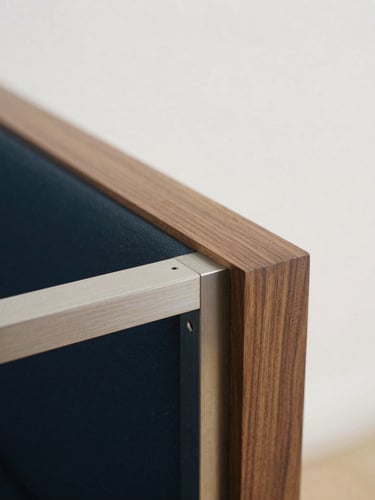 Macro photograph of master-level joinery, hand-rubbed walnut wood meeting brushed steel with millimeter-perfect tolerances, soft side lighting.
