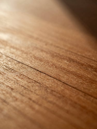 Macro close-up of natural wood grain on a cherry wood birth chart, showing subtle hand-carved grooves and physical textures, low-angled warm golden-hour light, deep natural shadows, 35mm film.