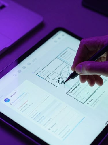 Close-up macro shot of a developer's hand sketching UI wireframes on a glowing tablet screen, moody studio lighting with vibrant electric violet backlighting, 35mm.